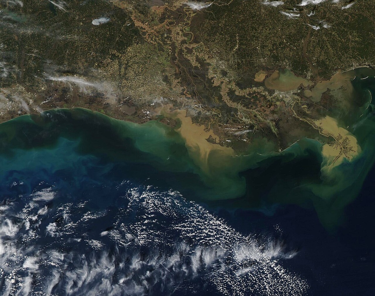 Satellite view of brown and green water spreading from the Louisiana coast into the deep blue Gulf of Mexico
